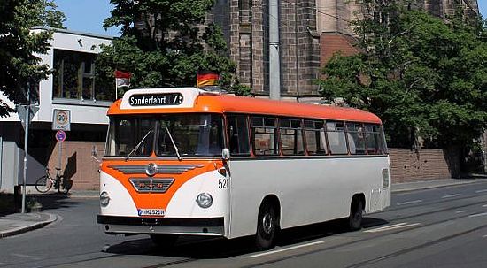 Oldtimerbus fährt an der Peterskirche in Nürnberg vorbei