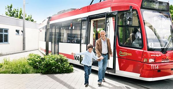 Mann und Kind verlassen eine moderne Straßenbahn