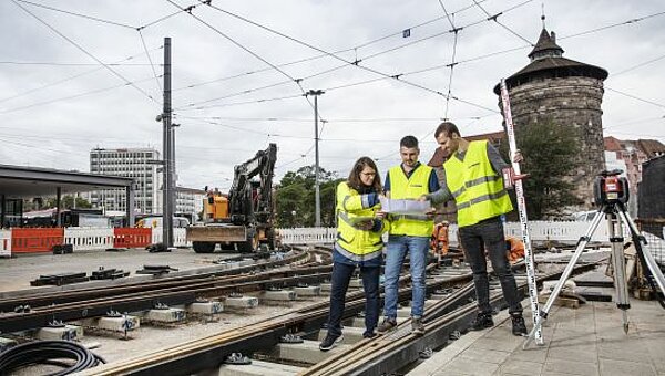 Petra Reißmann mit zwei weiteren Projektingenieuren auf einer Baustelle am Nürnberger Hauptbahnhof