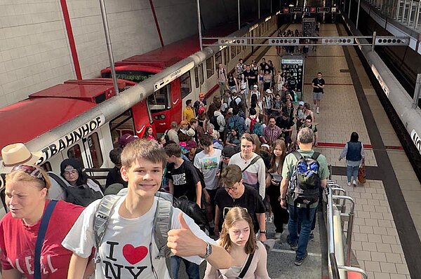 Ein Junge zeigt Daumen hoch auf dem Weg aus der U-Bahn-Station