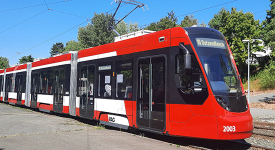 Straßenbahn des Typs Avenio an einer Haltestelle