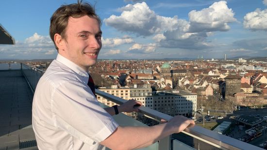 Adam Buschbacher, wie er von einer Hochhausterrasse auf Nürnberg blickt