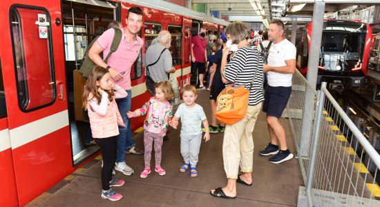 Familie vor einem U-Bahn-Zug des Typs DT1