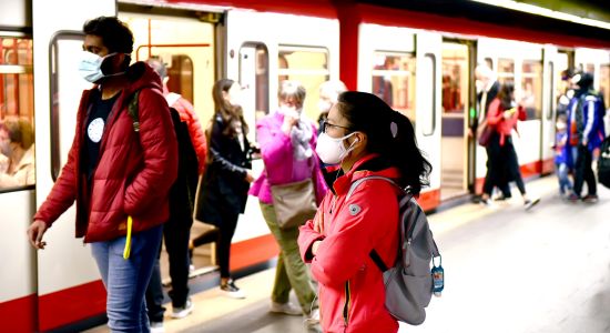 U-Bahnhof mit vielen Personen, die eine Maske tragen